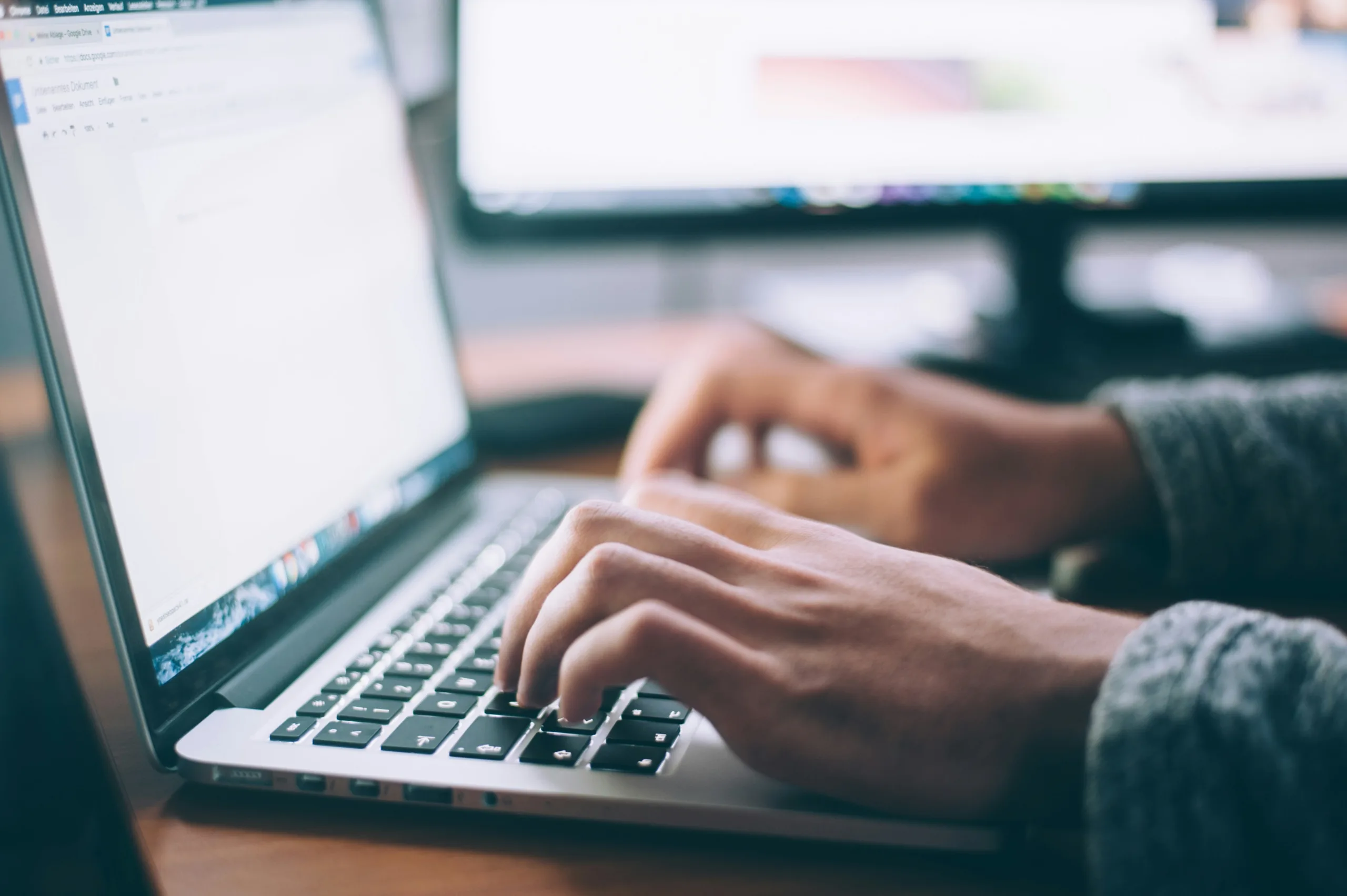 Person typing on an open MacBook